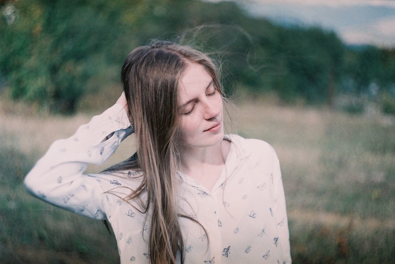 Woman with eyes closed standing on field