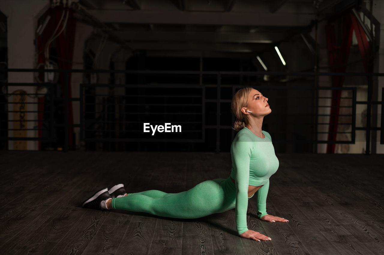 Full length of woman exercising on floor