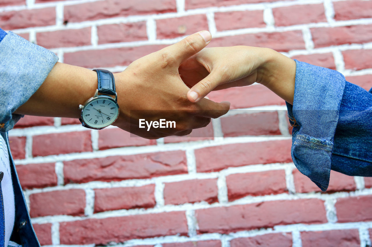 CLOSE-UP OF HAND AGAINST WALL