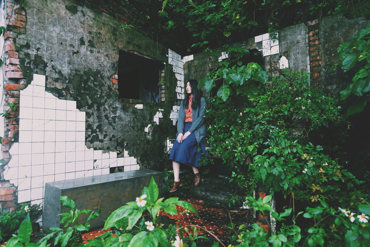 Portrait of woman in front of abandoned building