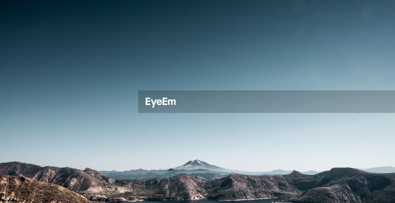 Scenic view of lake and mountain range against clear sky