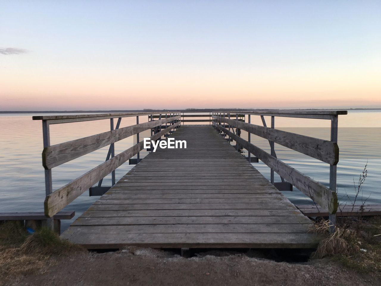 Pier over river at sunset