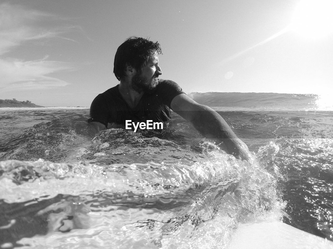 Man with surfboard in sea against sky