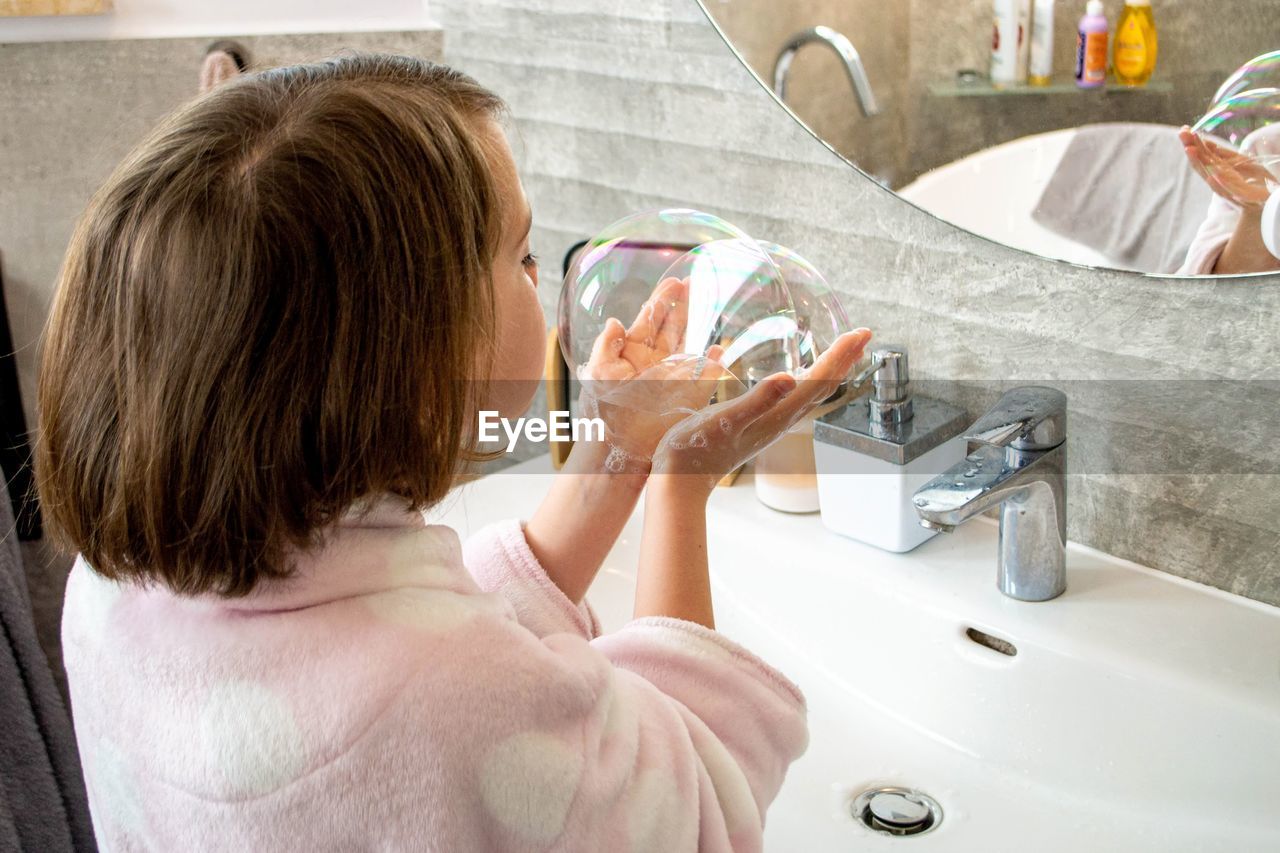 Relaxed young girl model poses in cozy bathroom