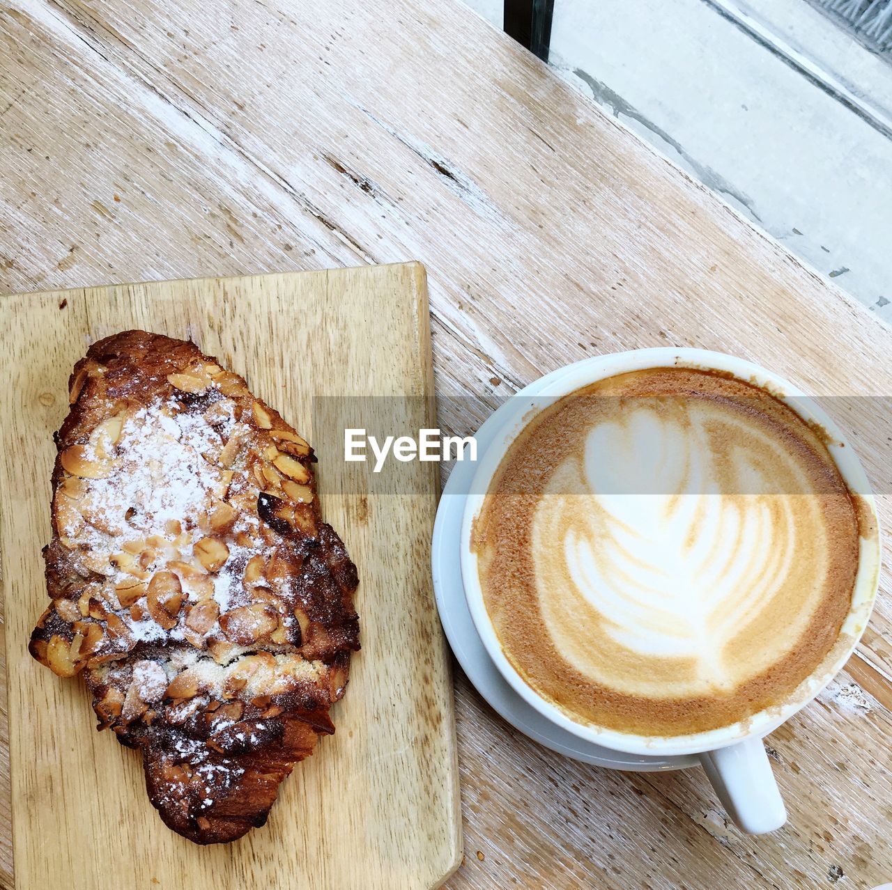 High angle view of coffee cup with roasted ham on table