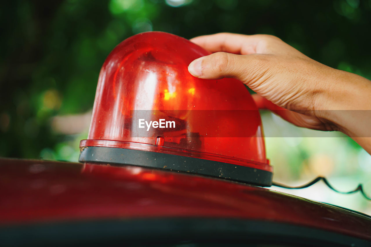 Cropped hand of person touching emergency siren