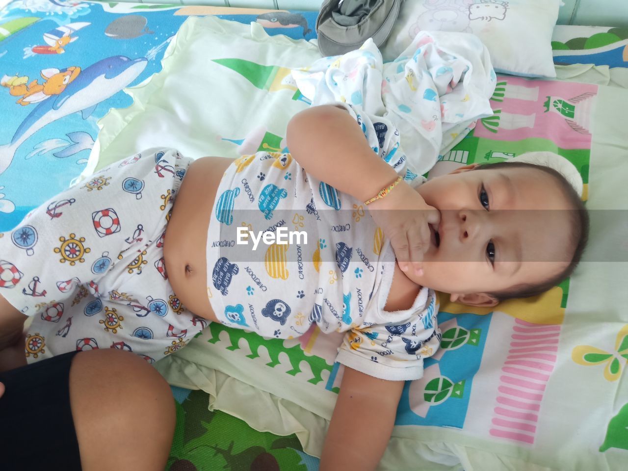 HIGH ANGLE VIEW OF BABY LYING ON BED