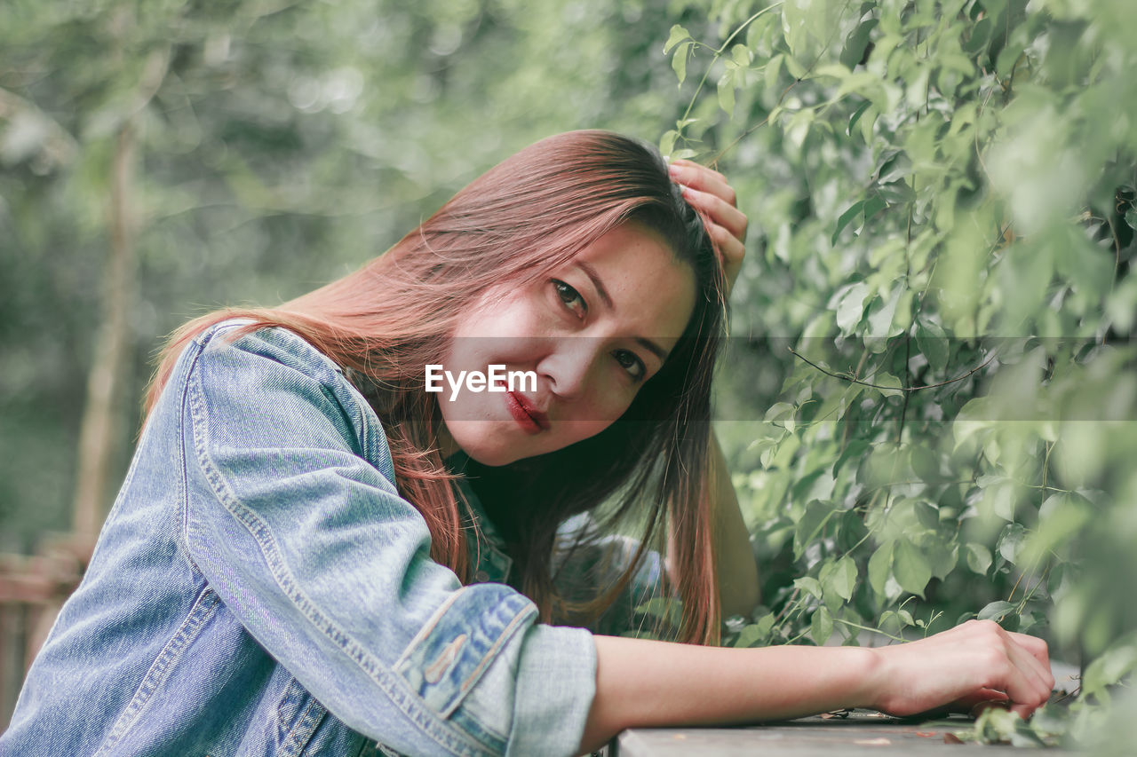 Side view portrait of beautiful woman by plants