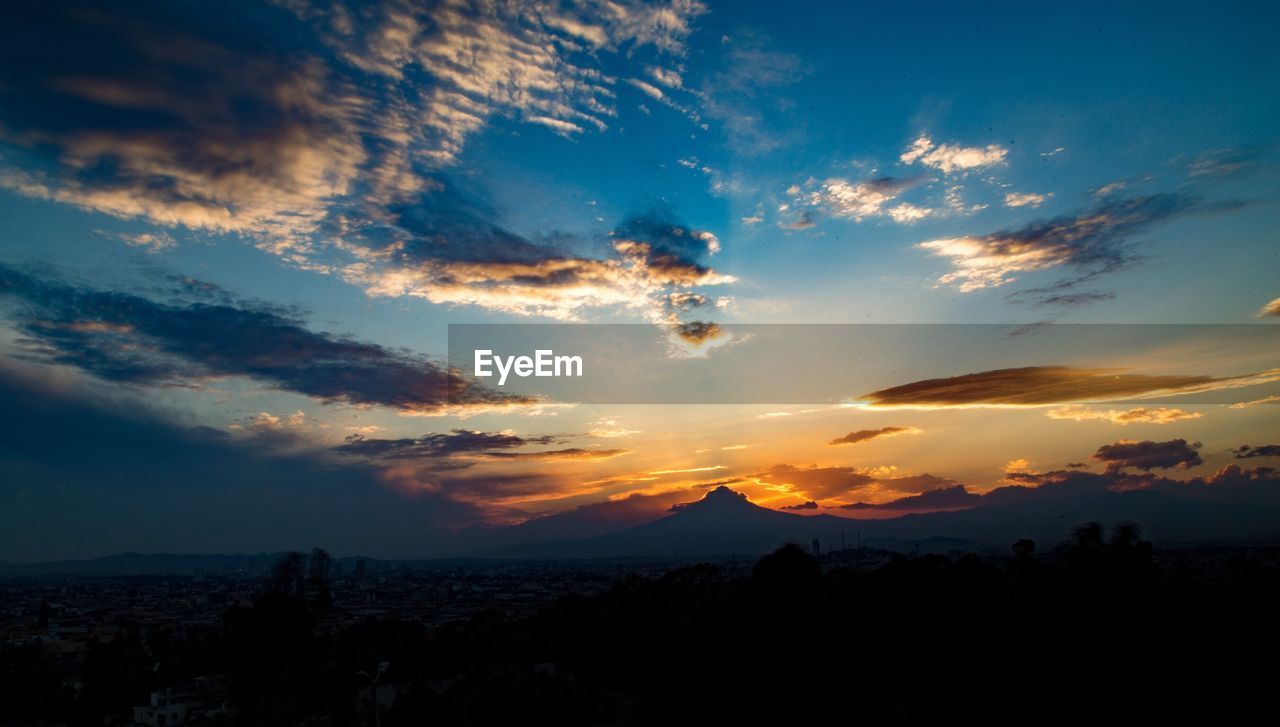 SCENIC VIEW OF SUNSET OVER MOUNTAINS