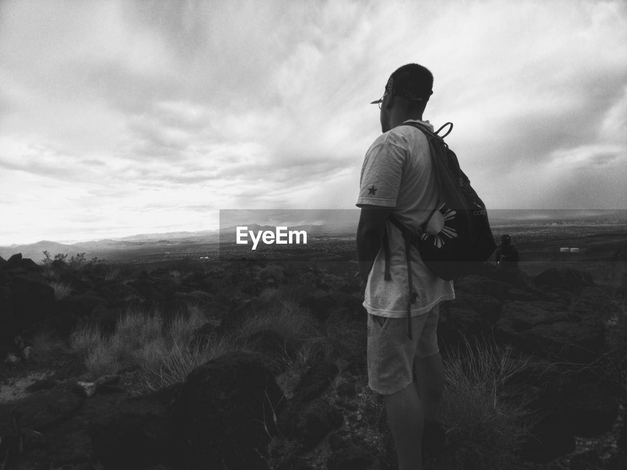 REAR VIEW OF MAN WALKING ON LANDSCAPE AGAINST SKY