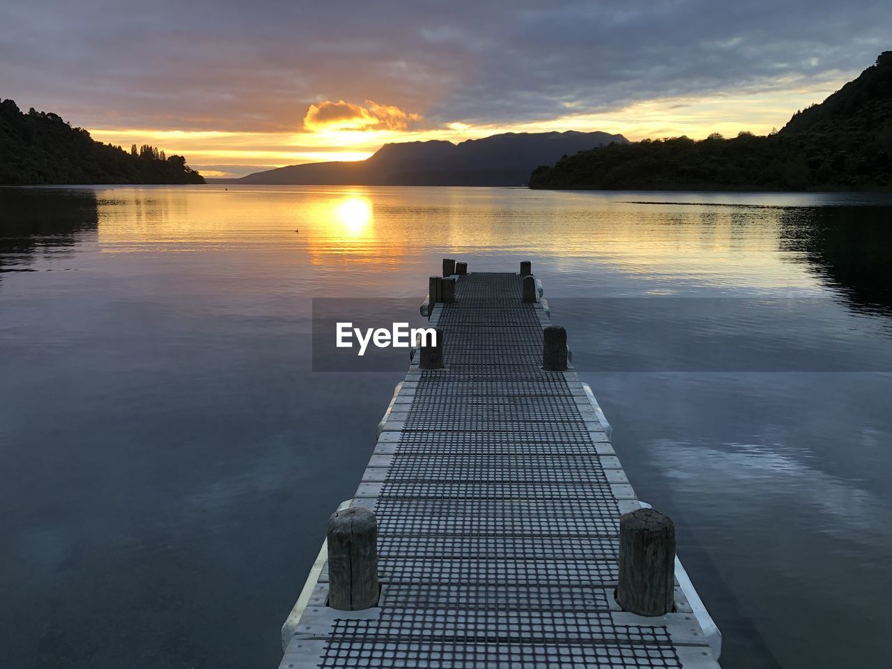 Pier on lake against sky during sunrise, lake tarawera new zealand 