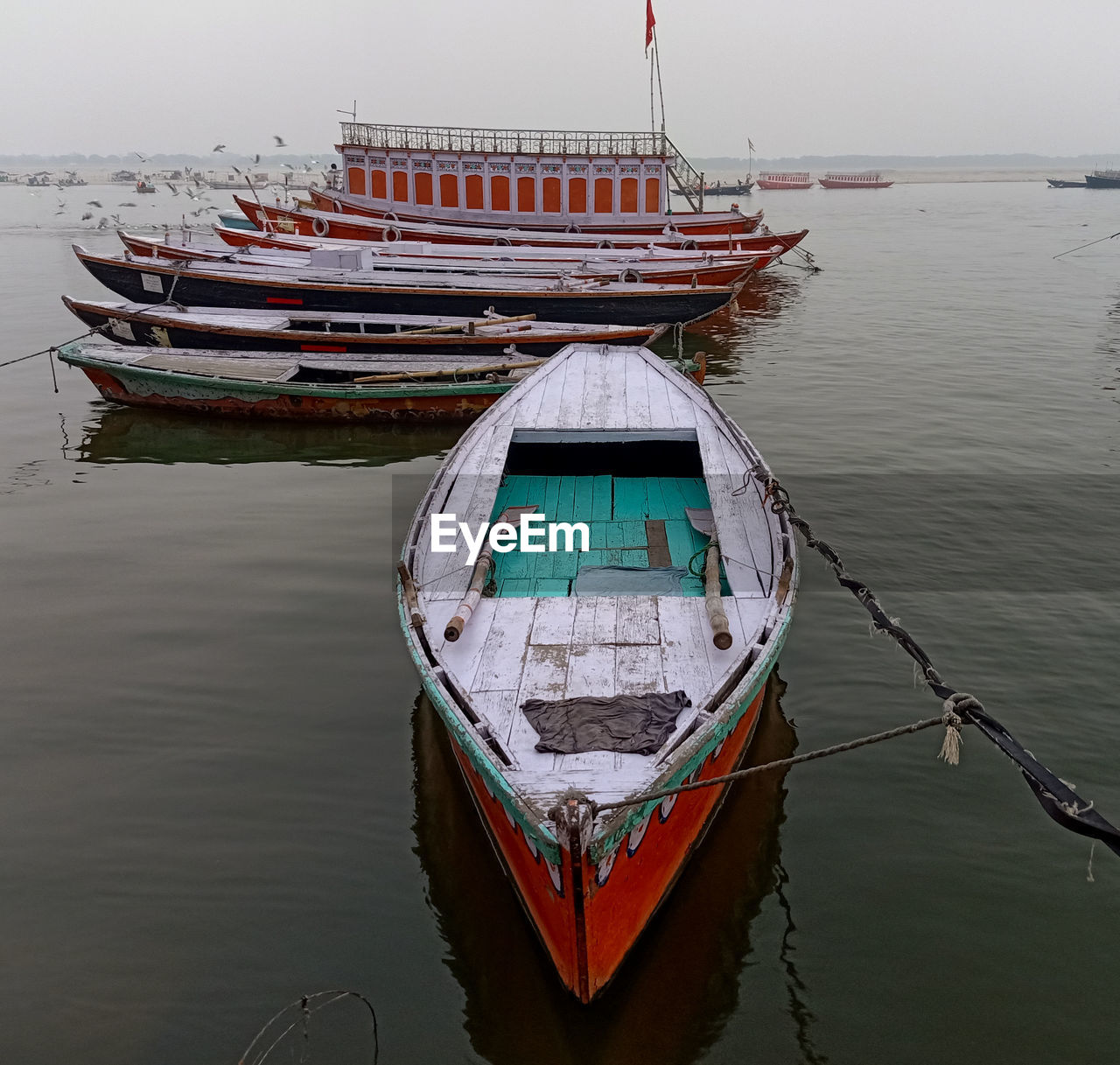 BOAT MOORED ON SEA AGAINST SKY