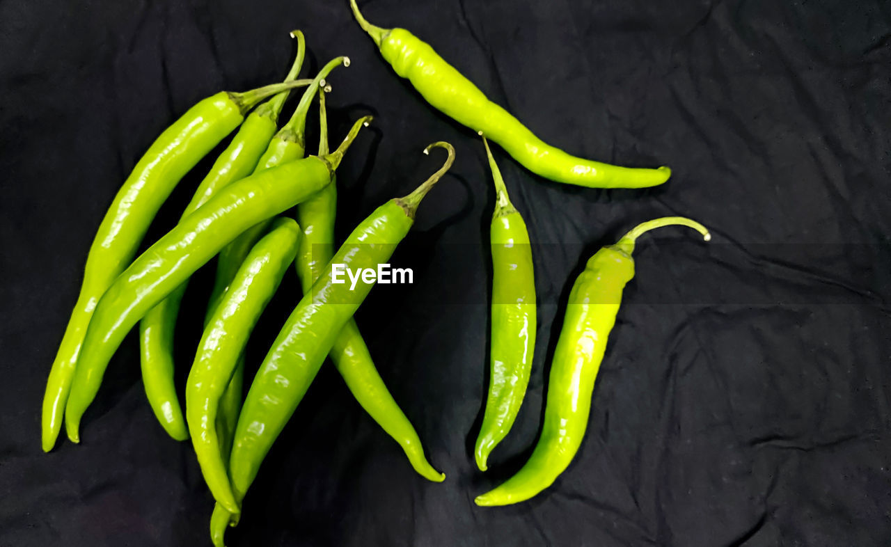 CLOSE-UP OF GREEN CHILI PEPPER ON TABLE