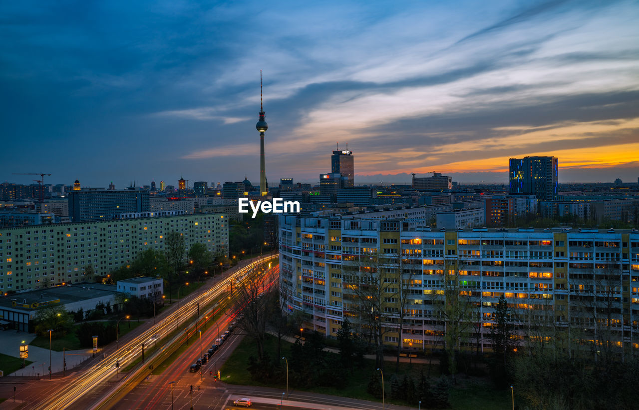 Illuminated buildings and television tower - berlin against sky during sunset
