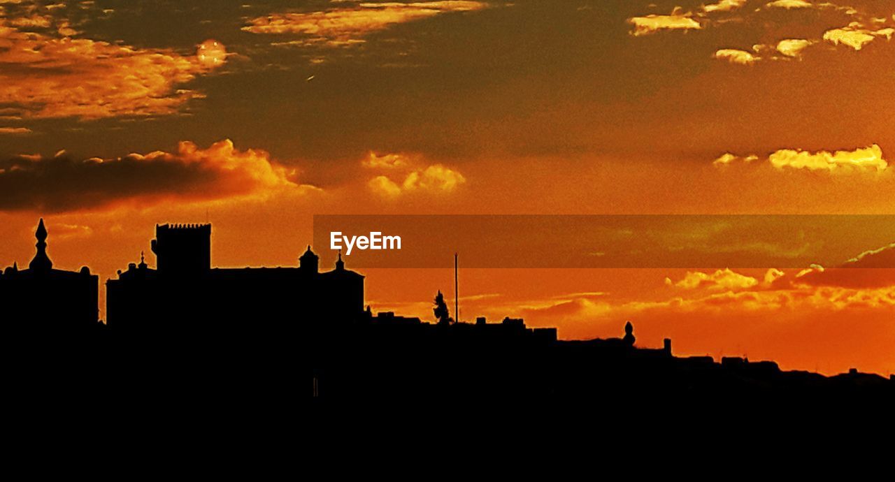 SILHOUETTE OF BUILDINGS AGAINST SKY DURING SUNSET