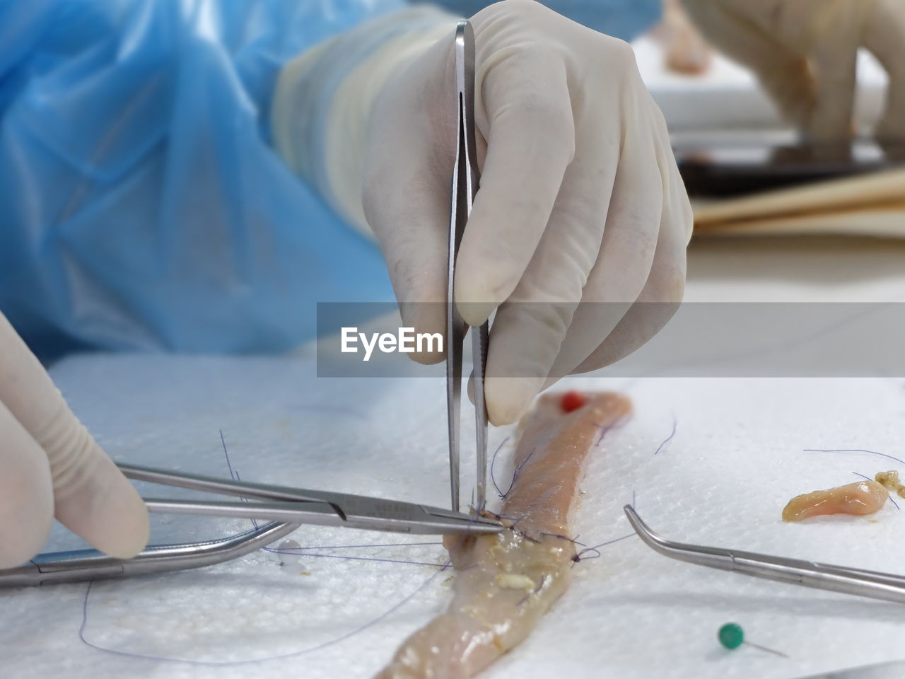 cropped hand of dentist examining patient on table