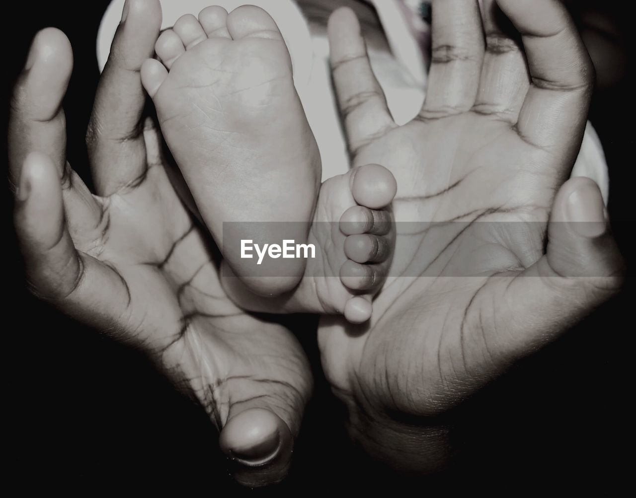 Close-up of father holding baby feet