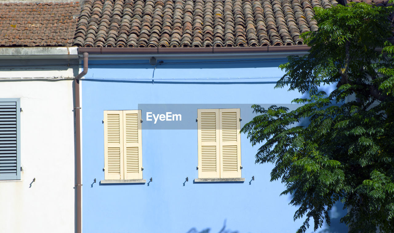 architecture, building exterior, built structure, building, window, facade, tree, house, no people, home, day, plant, residential district, nature, outdoors, roof, wall, blue, city, sky, sunlight, low angle view, residential area