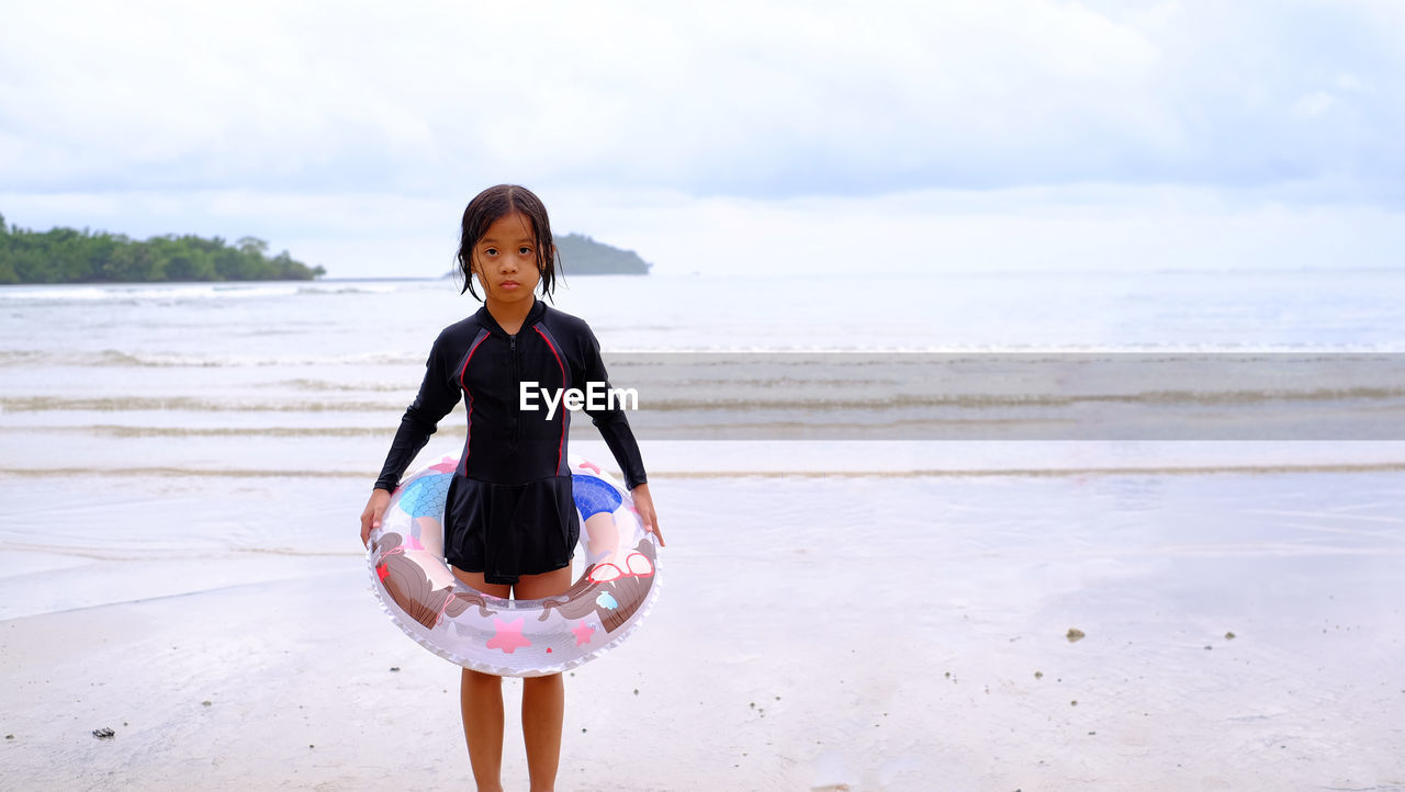 FULL LENGTH PORTRAIT OF WOMAN STANDING ON BEACH