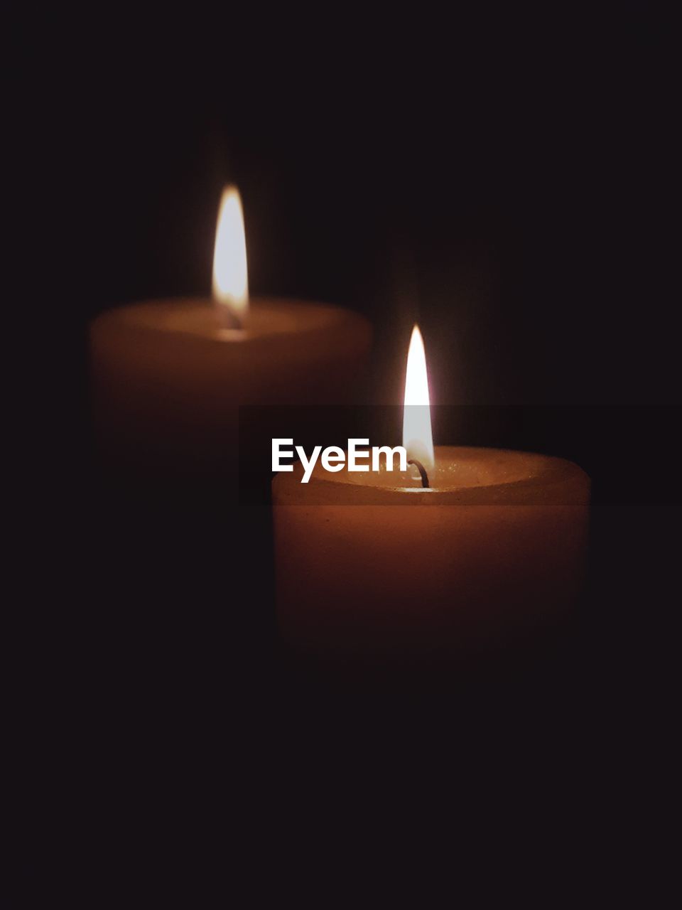 Close-up of lit candles against black background