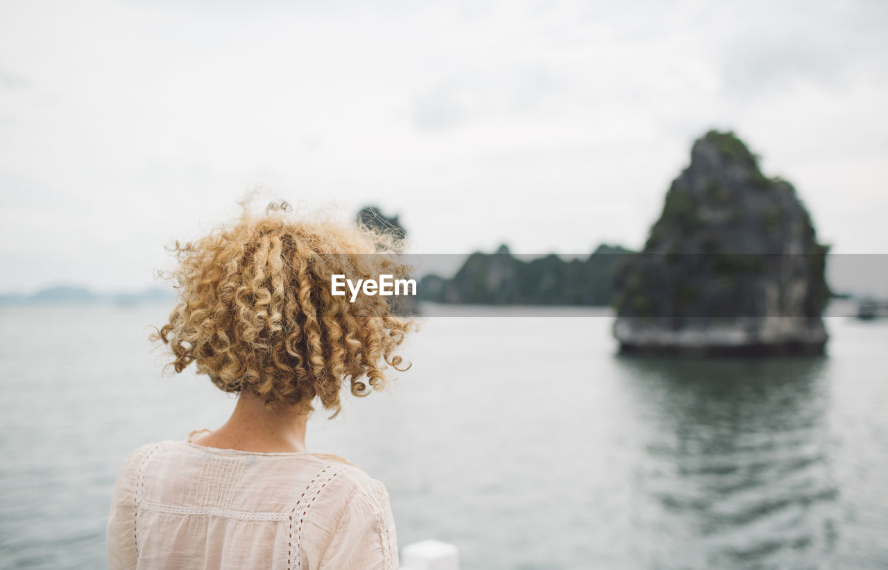 Rear view of woman looking at sea against sky