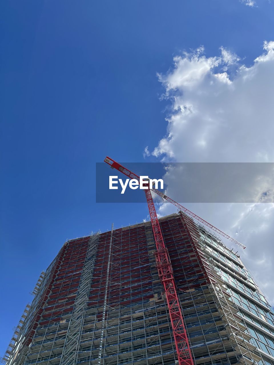 LOW ANGLE VIEW OF CRANE ON BUILDING AGAINST SKY