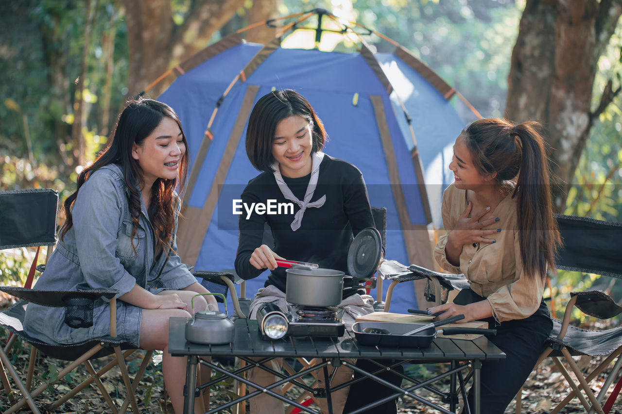 Three bestie go camping in the forest and take a photos while cooking