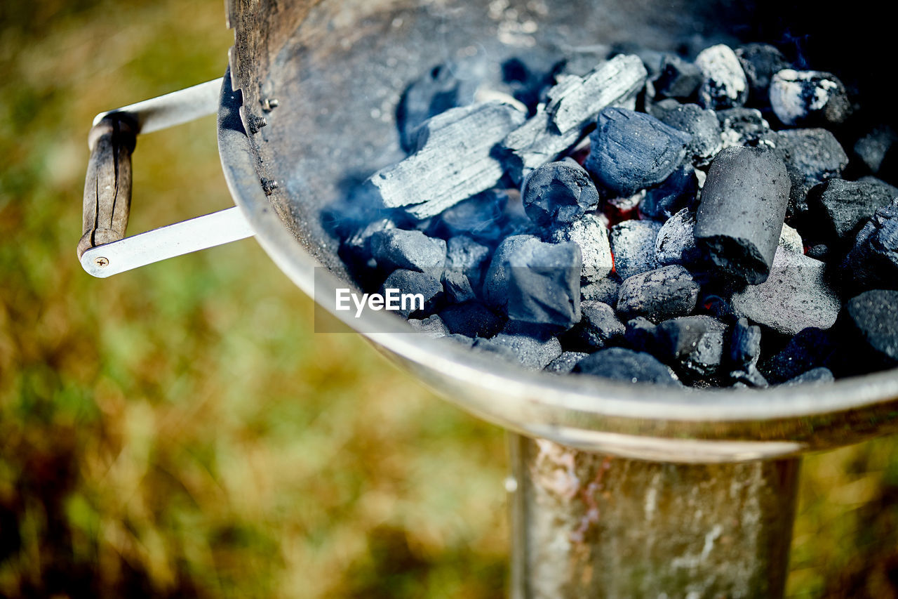 Closeup of glowing coal in metal grill on summer day in the garden