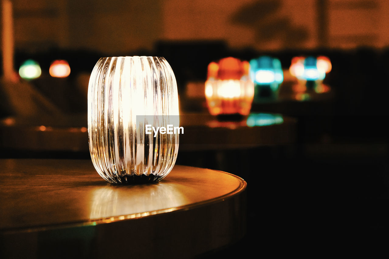 Close-up of illuminated light bulb on table in restaurant