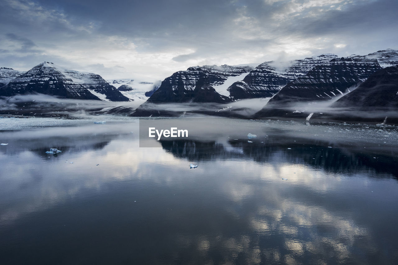 Scenic view of lake and snowcapped mountains against sky