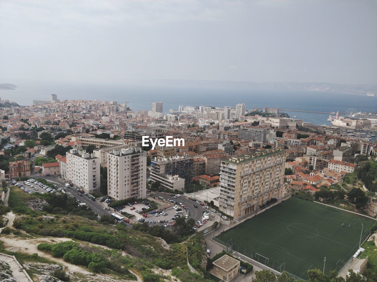 HIGH ANGLE VIEW OF BUILDINGS AND TREES AGAINST SKY