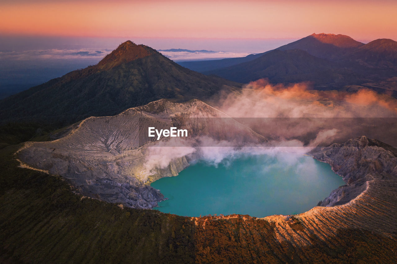 PANORAMIC VIEW OF VOLCANIC MOUNTAINS AGAINST SKY DURING SUNSET