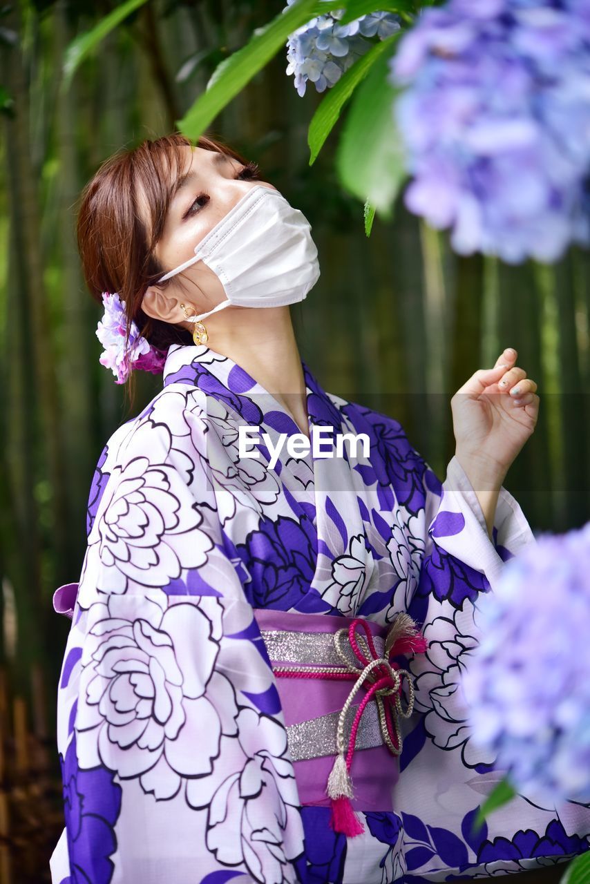 Portrait of woman with pink flowers against blurred background