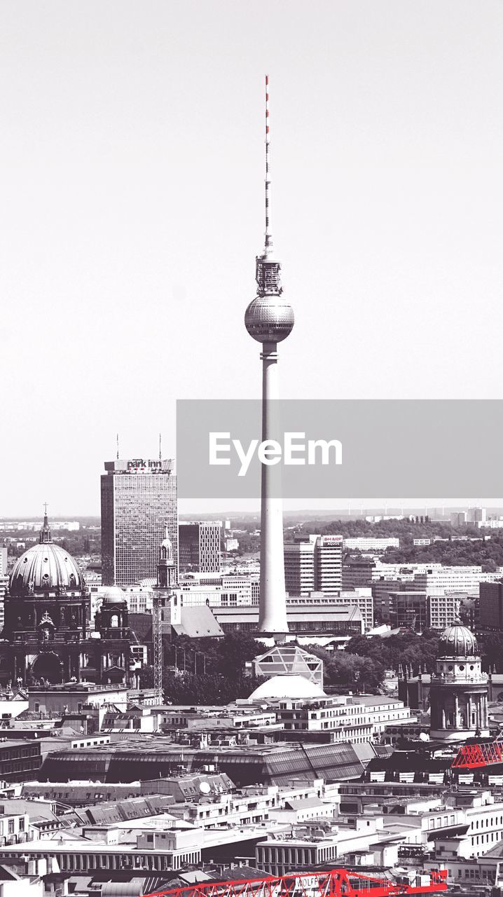 Fernsehturm tower amidst buildings against clear sky in city