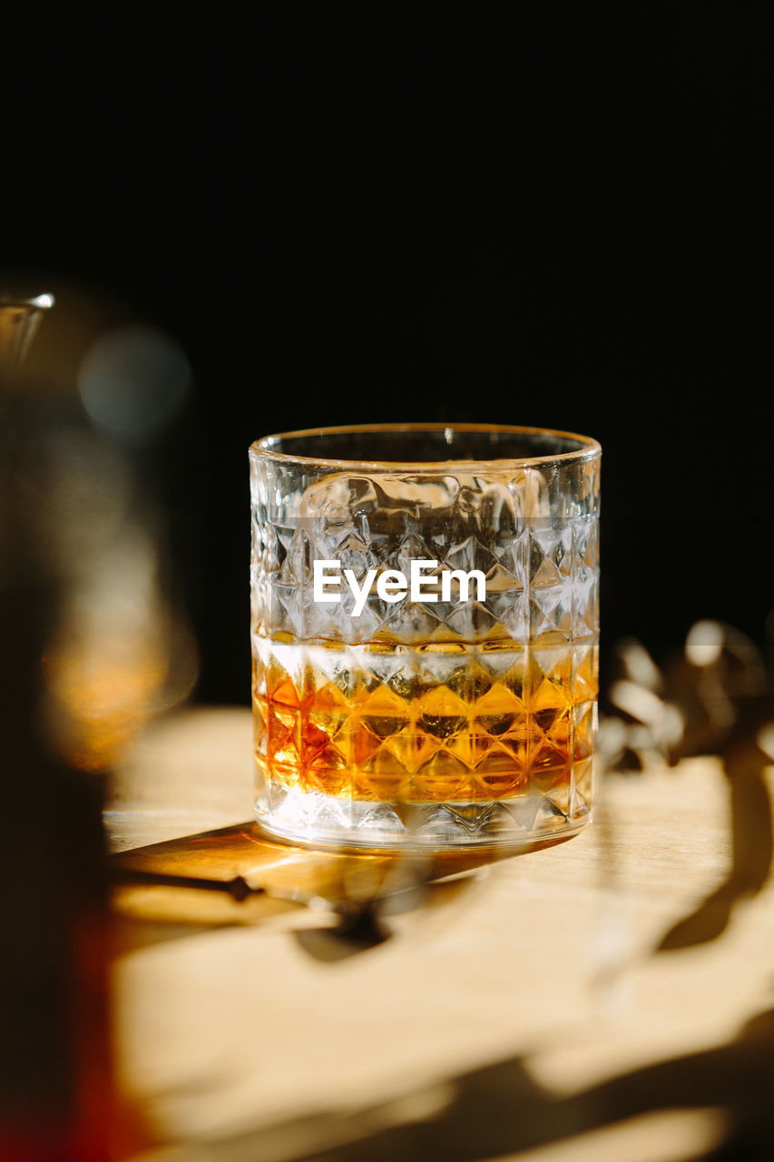 Close-up of glass with bourbon whiskey on table