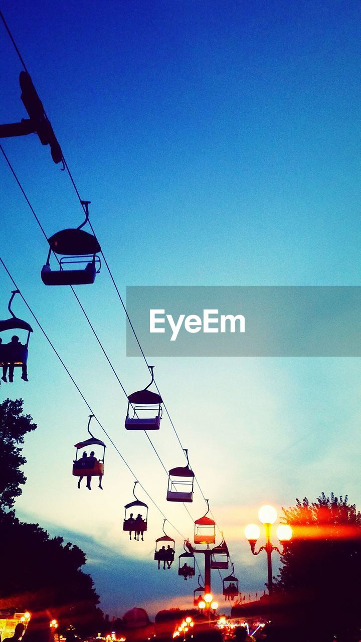 LOW ANGLE VIEW OF OVERHEAD CABLE CARS AGAINST CLEAR SKY