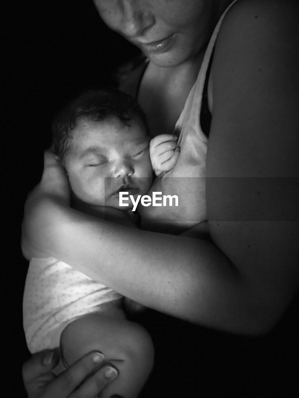 Midsection of mother with baby in darkroom