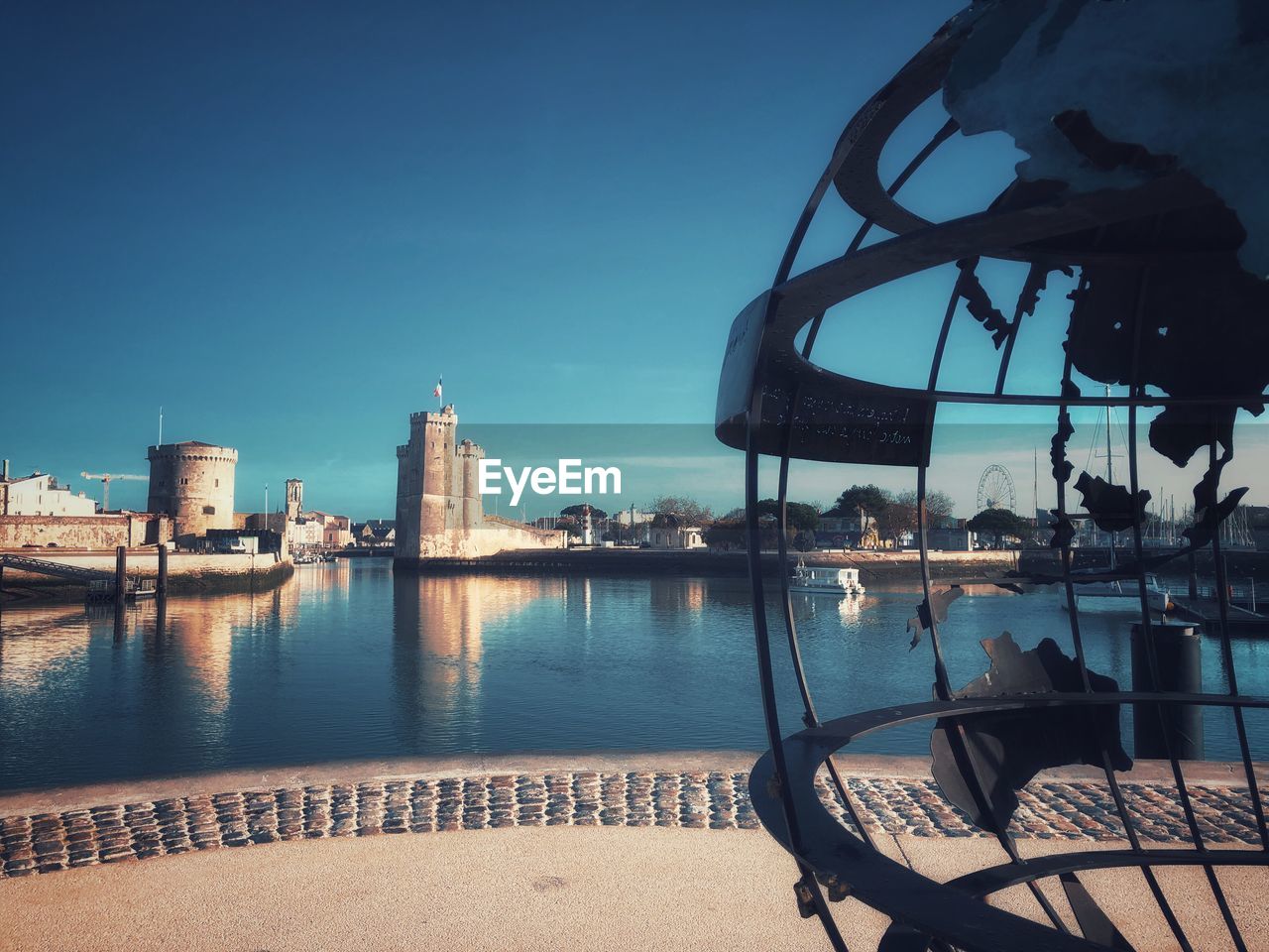 SCENIC VIEW OF RIVER BY BUILDINGS AGAINST BLUE SKY