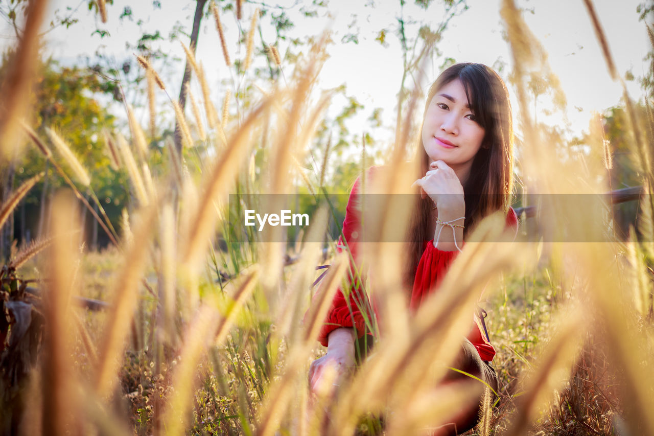 PORTRAIT OF YOUNG WOMAN ON FIELD