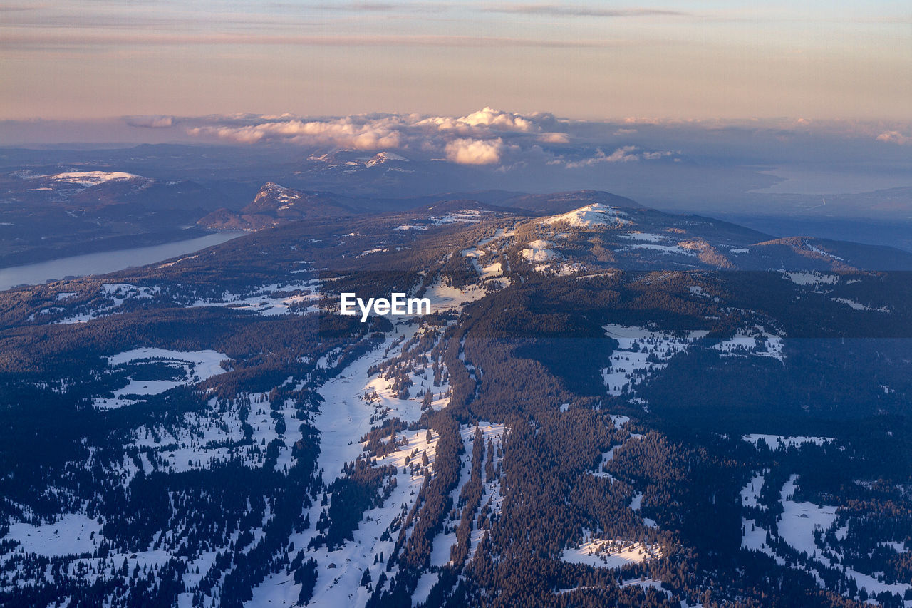 Aerial view of snowcapped mountains against sky during sunset