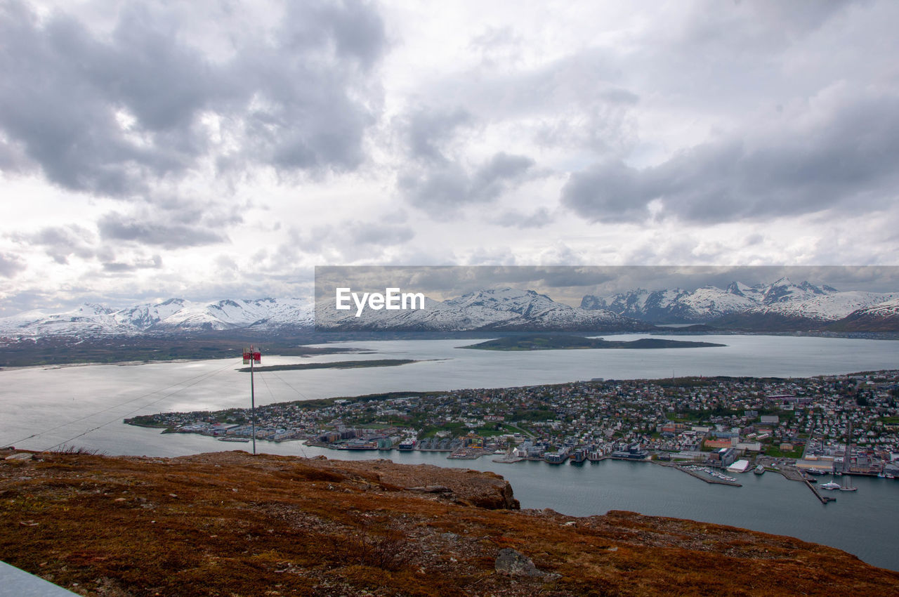 Scenic view of sea by buildings against sky