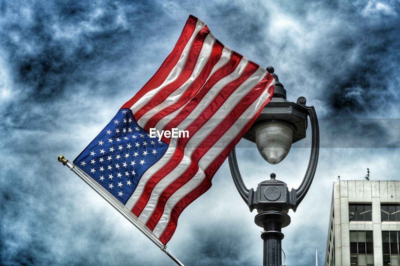 Low angle view of american flag against cloudy sky