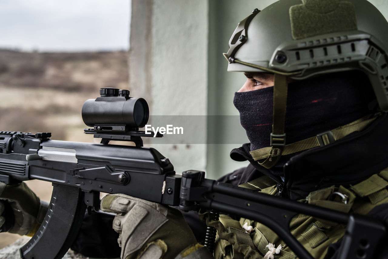 Close-up of army soldier aiming gun