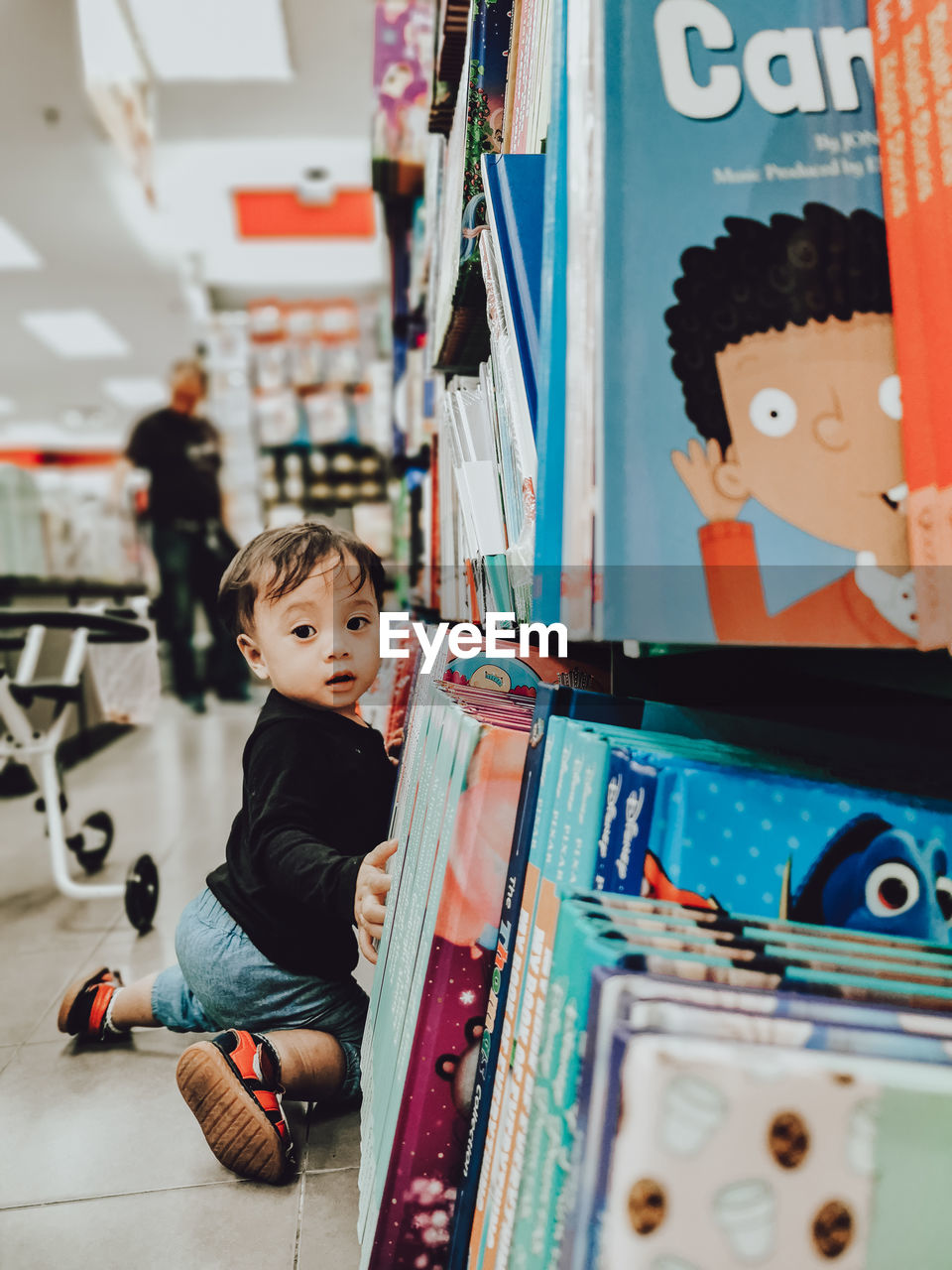 BOY LOOKING AT CAMERA IN STORE
