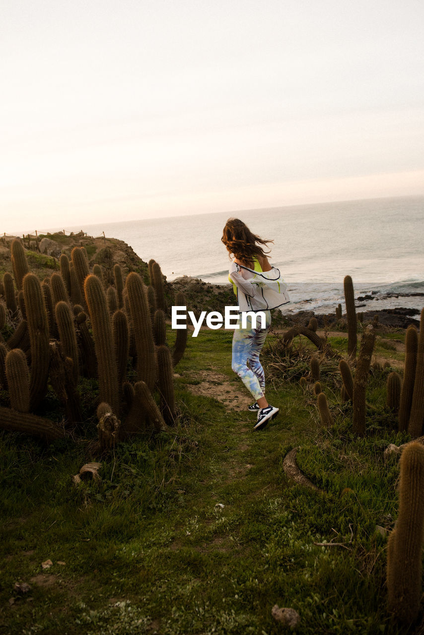 Female hiker catches the last light on the stunning coast of chile.