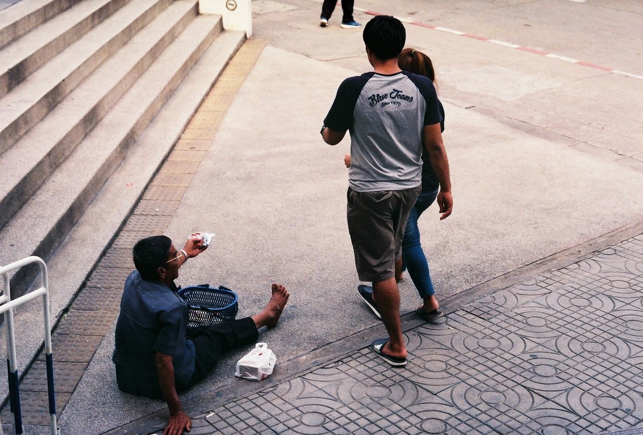 REAR VIEW OF MEN WALKING ON STREET