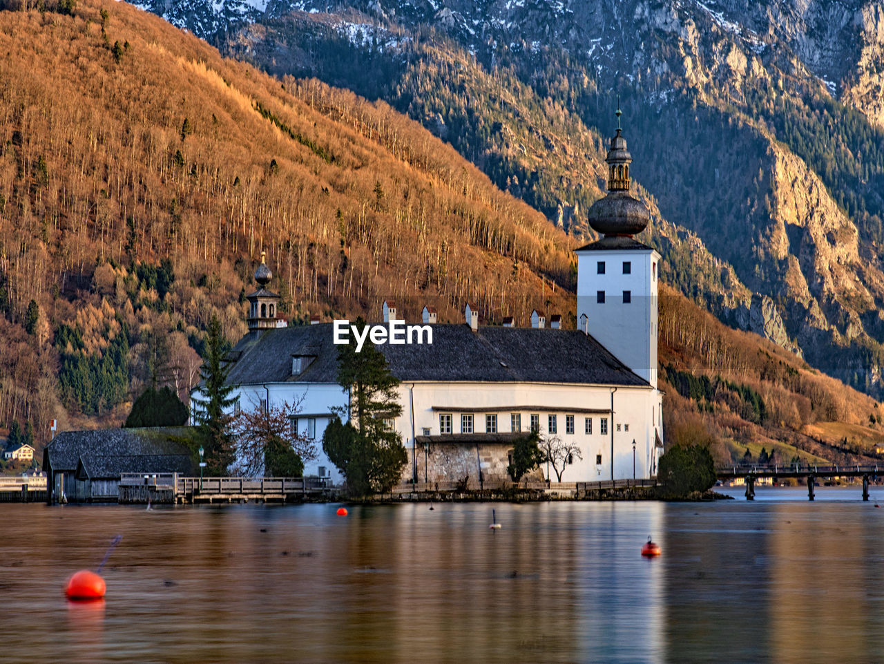 VIEW OF BUILDINGS AT WATERFRONT AGAINST MOUNTAIN