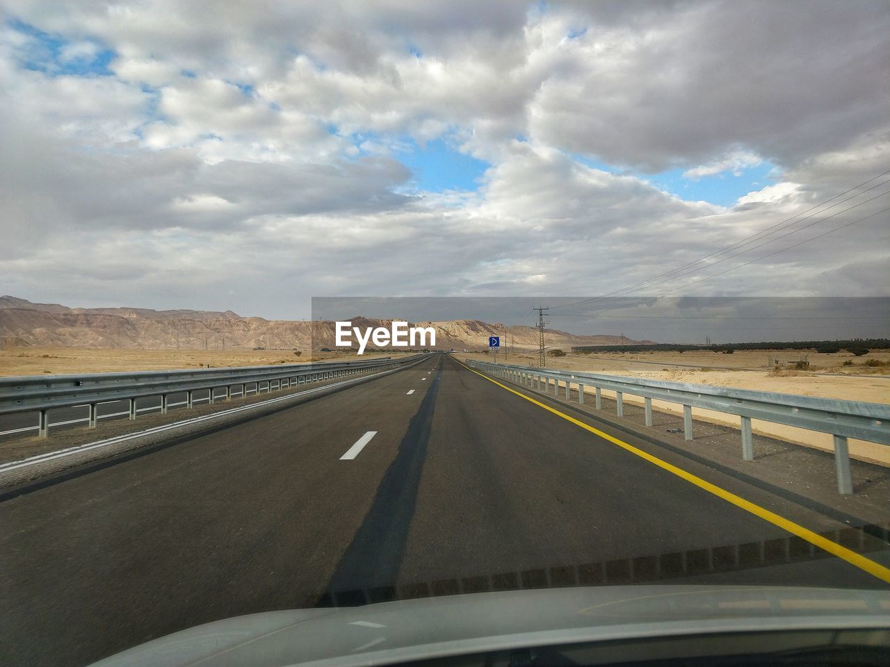 ROAD SEEN THROUGH WINDSHIELD OF CAR