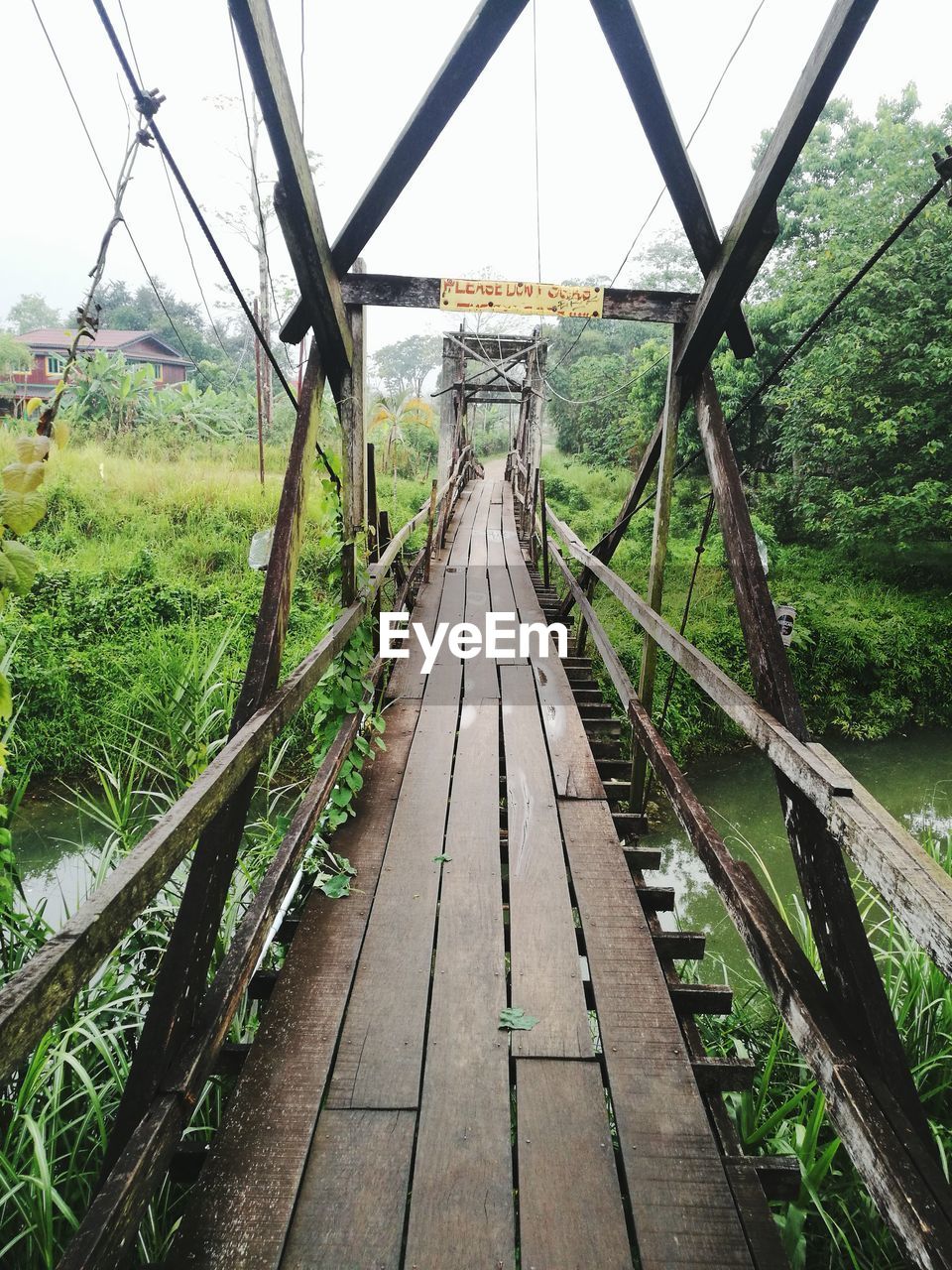 RAILROAD TRACKS BY BRIDGE AGAINST SKY