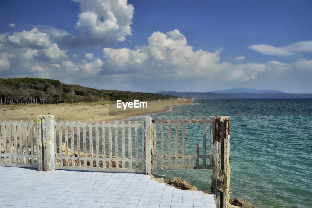 Wooden posts on the beach against sky